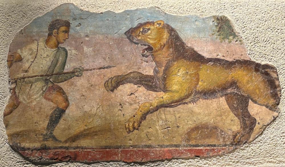 Pintura mural romana de un venator frente a un león