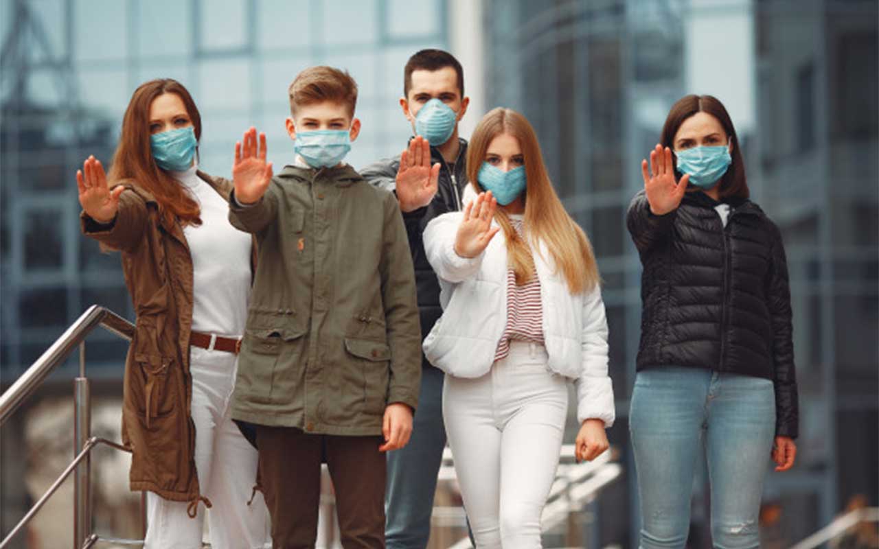 Personas con mascarilla haciendo un gesto de stop, simbolizando la prevención ante pandemias