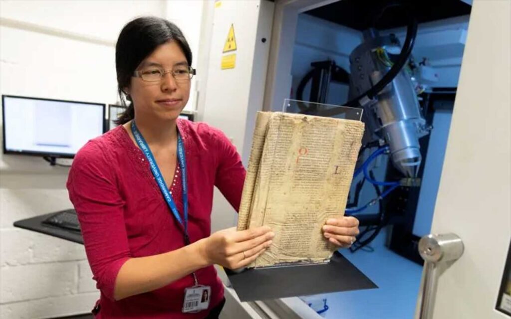 Dr. Irène Fabry-Tehranchi carefully holding the rare Merlin manuscript fragment before inserting it into the Micro CT scanner at the University of Cambridge’s Department of Zoology