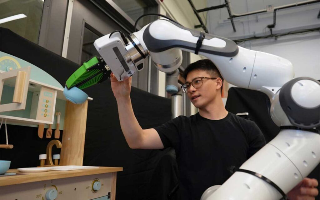 A robot assisting a person in picking up a bowl.